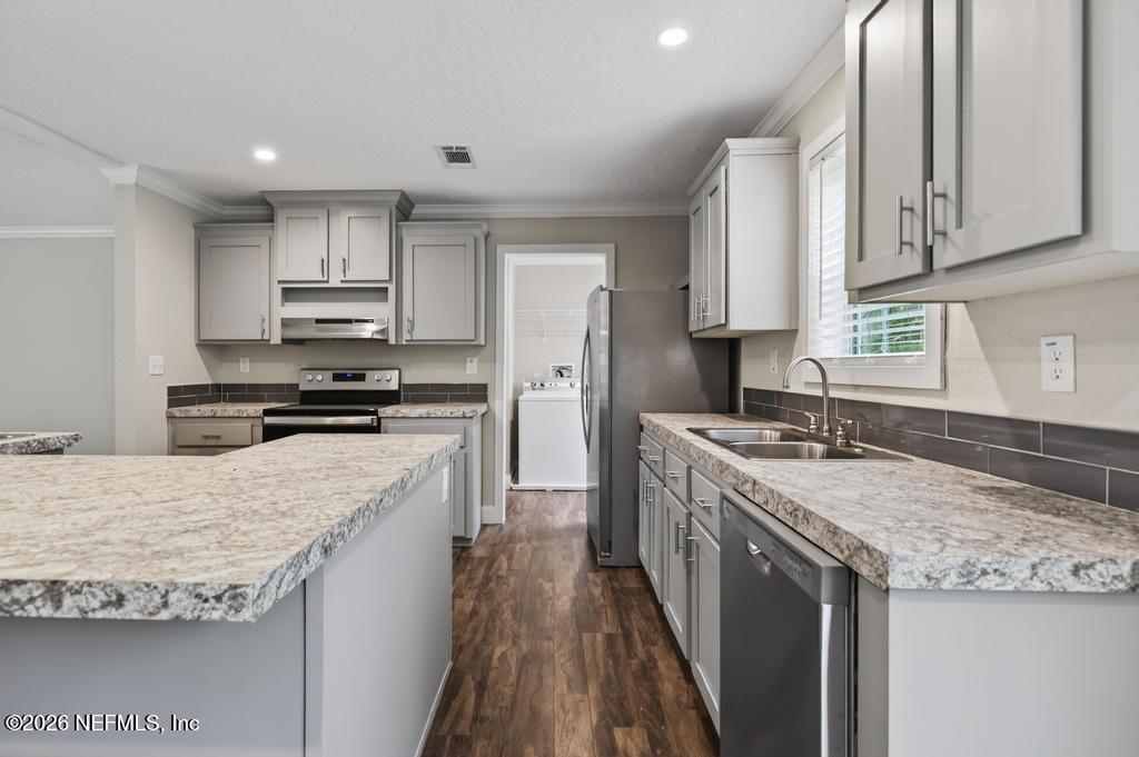 95605 Springhill Road Fernandina Beach, FL 32034 - Photo 16 of 62 a kitchen with stainless steel appliances granite countertop a sink stove and refrigerator