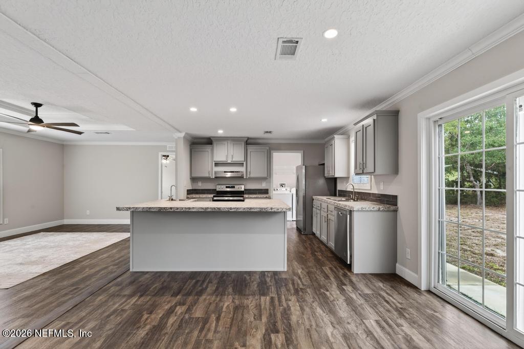95605 Springhill Road Fernandina Beach, FL 32034 - Photo 19 of 62 a kitchen with stainless steel appliances a sink a stove a refrigerator cabinets and a large window