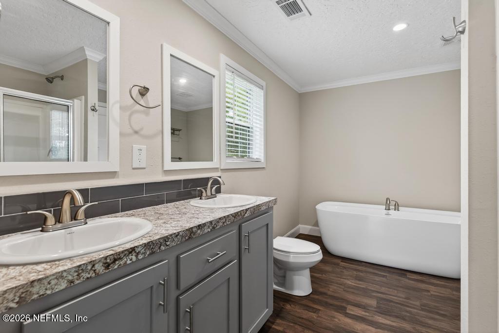 95605 Springhill Road Fernandina Beach, FL 32034 - Photo 34 of 62 a bathroom with a granite countertop sink a toilet and a mirror