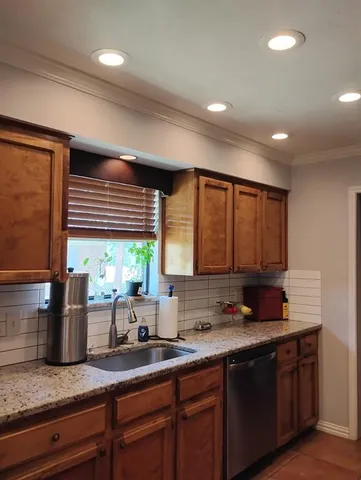 a kitchen with granite countertop cabinets sink and window