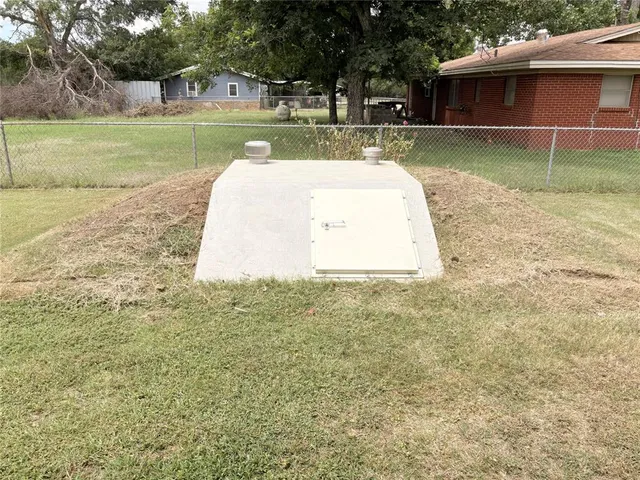 a view of a backyard with table and chairs under an umbrella