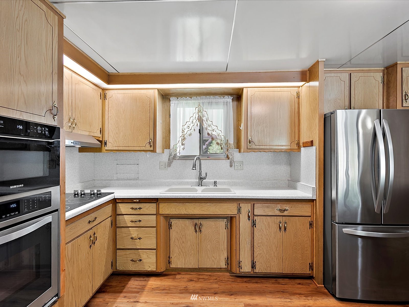 3333 228th Street Southeast, Unit 98 Bothell, WA 98021 - Photo 4 of 18 a kitchen with stainless steel appliances a refrigerator sink and cabinets