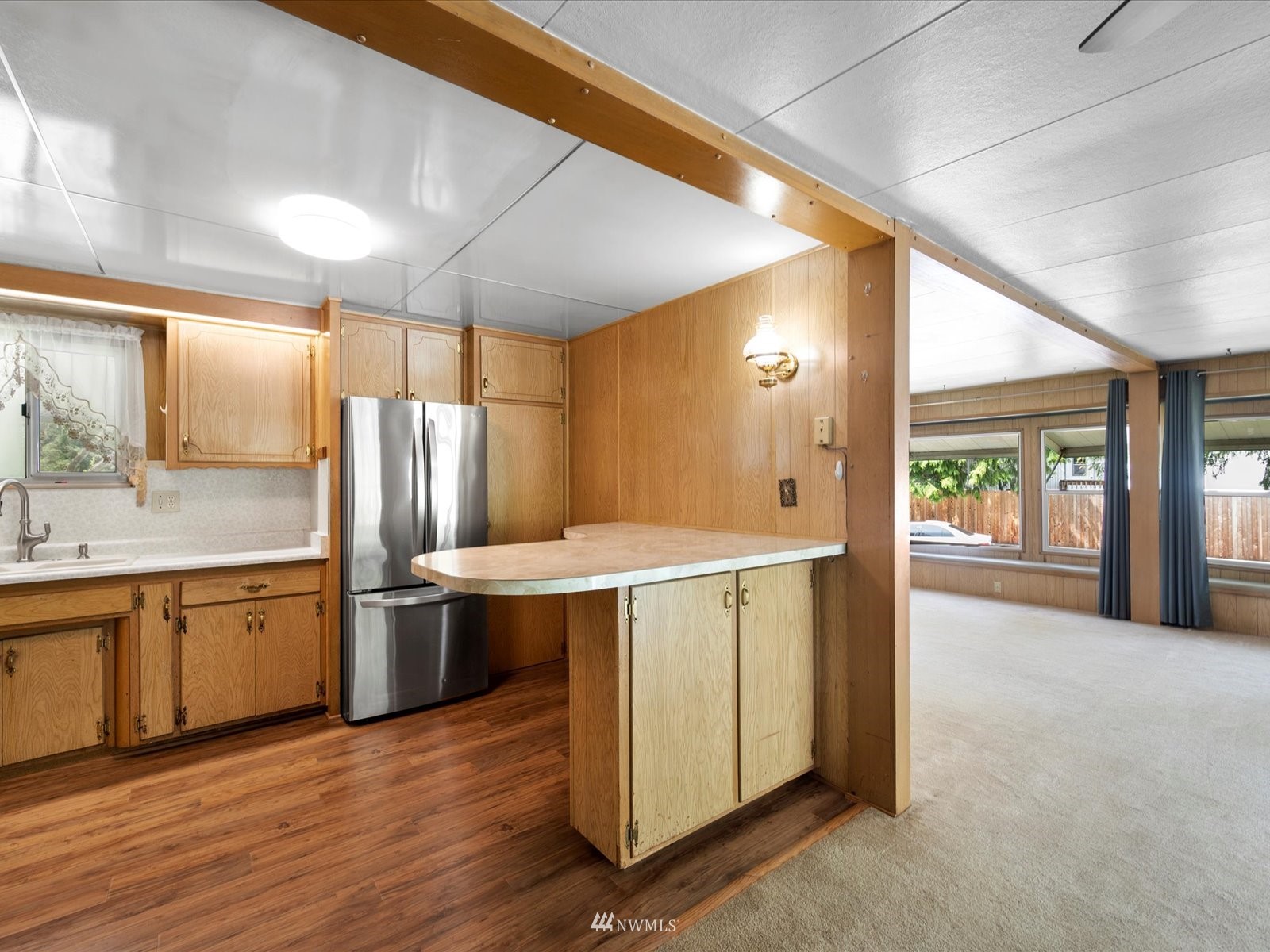 3333 228th Street Southeast, Unit 98 Bothell, WA 98021 - Photo 5 of 18 a kitchen with stainless steel appliances granite countertop a refrigerator a sink dishwasher and a fireplace with wooden floor