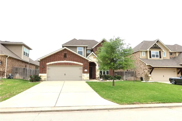 a front view of a house with a yard and trees