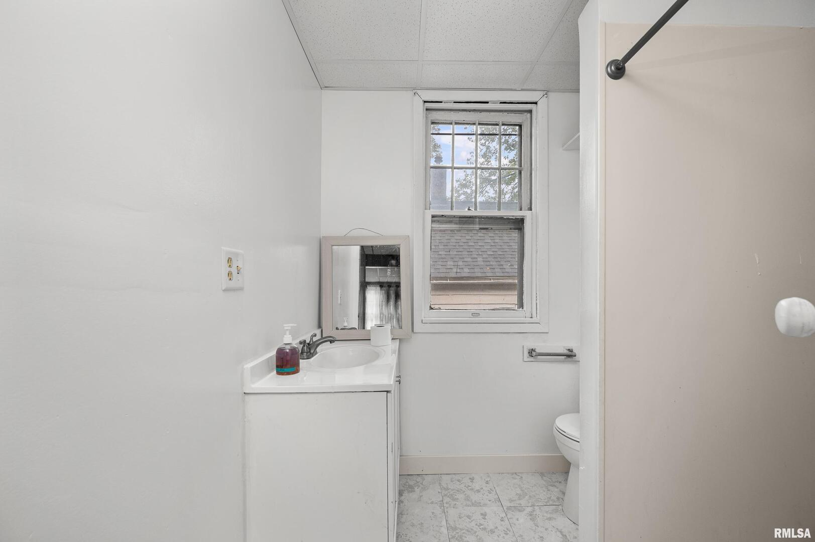 158 5th Street Silvis, IL 61282 - Photo 8 of 23 a bathroom with a sink a toilet and mirror