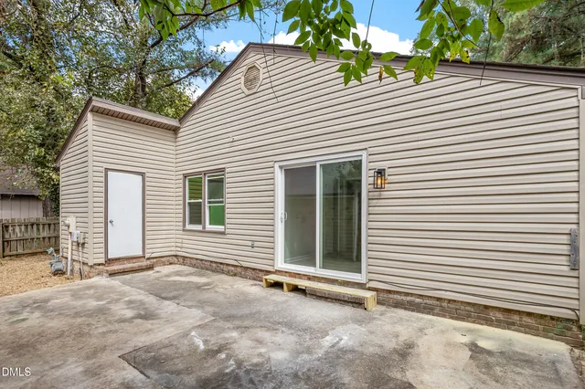 a view of a backyard with a large tree and wooden fence