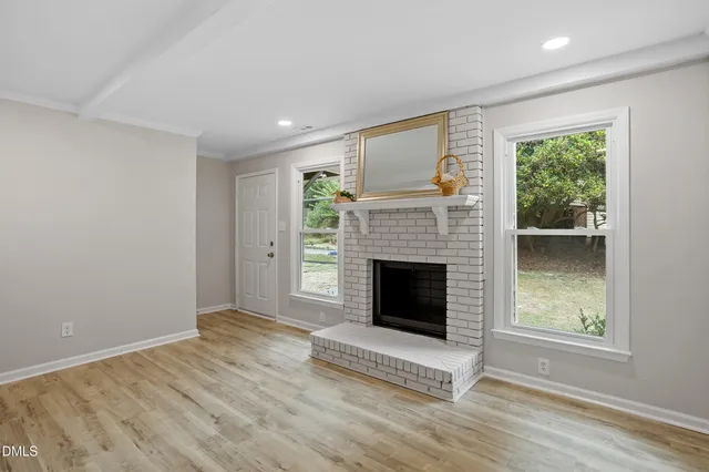 a view of a livingroom with a fireplace and window