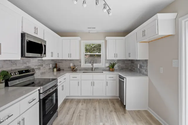 a kitchen with a sink stove and white cabinets