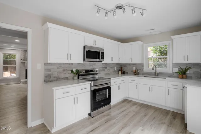 a kitchen with cabinets stainless steel appliances and a window