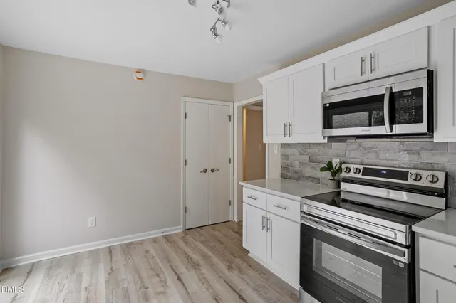 a kitchen with stainless steel appliances a stove a microwave and cabinets