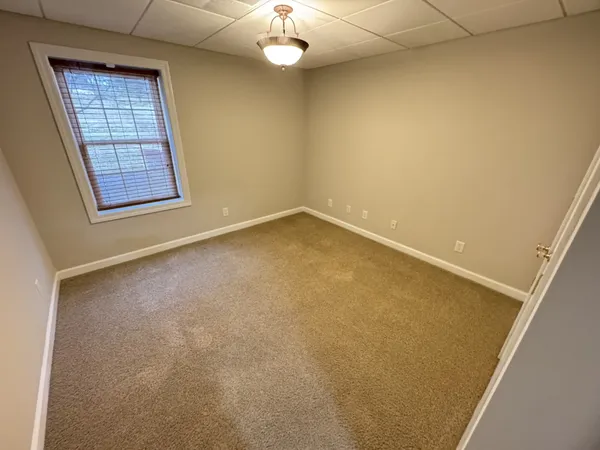 an empty room with a ceiling fan and window