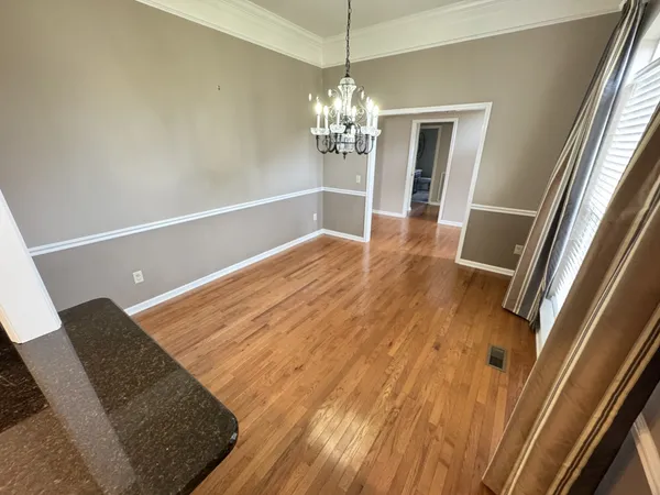 a view of a living room with wooden floor and stairs