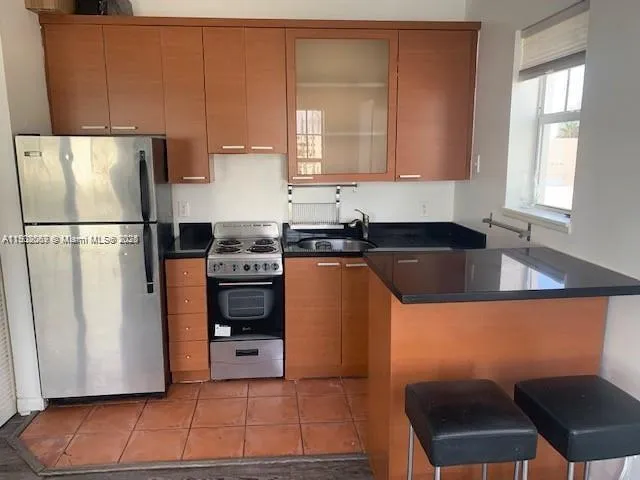 a kitchen with a refrigerator a stove a sink and a window