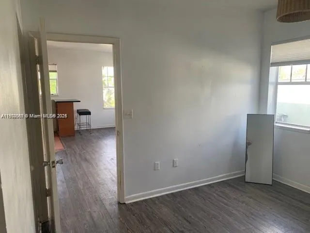 an empty room with wooden floor and a window