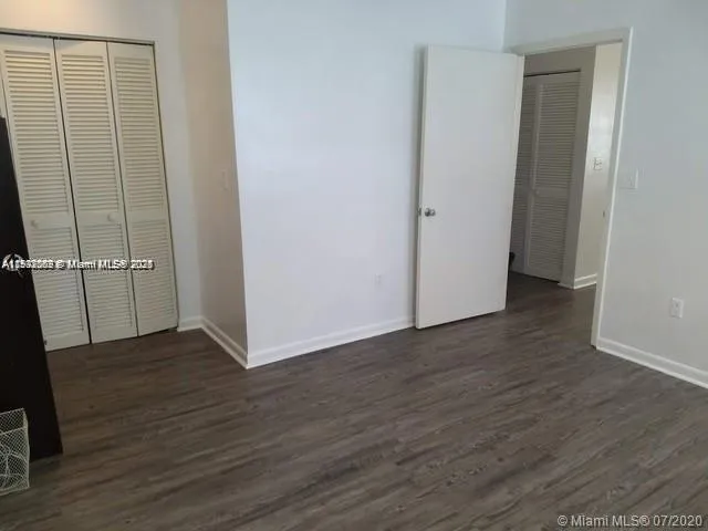 an empty room with wooden floor and closet