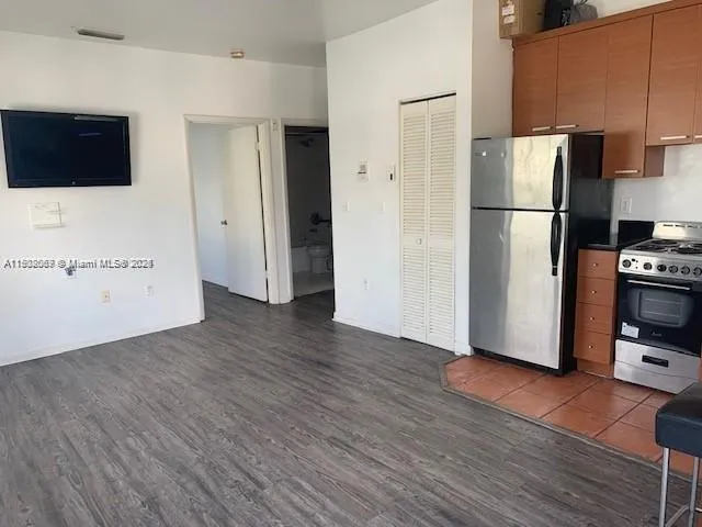 a view of a kitchen with wooden floor and electronic appliances