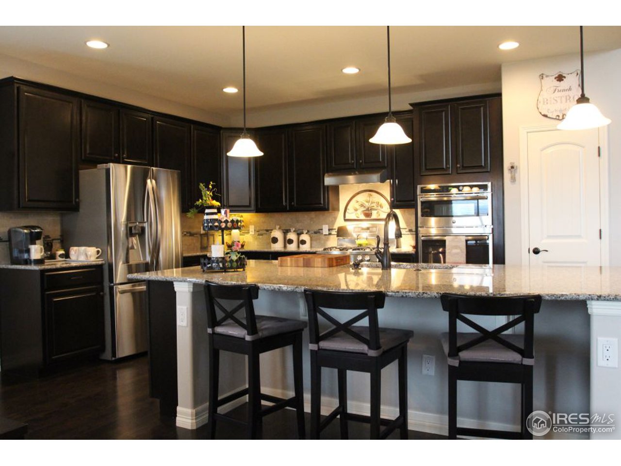 3319 Tranquility Way Berthoud, CO 80513 - Photo 14 of 40 a kitchen with refrigerator a sink cabinets and wooden floor