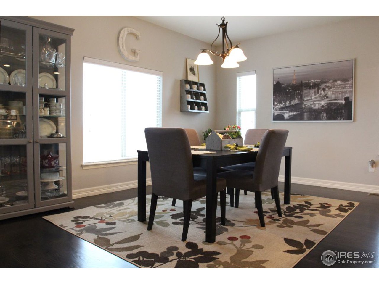 3319 Tranquility Way Berthoud, CO 80513 - Photo 18 of 40 a dining room with wooden floor a chandelier a wooden table and chairs