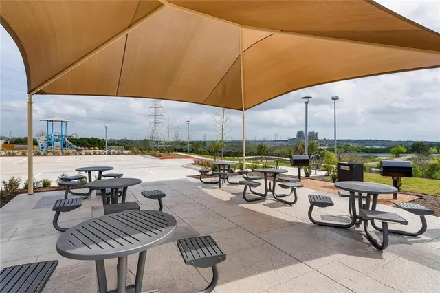 a view of a patio with couches and chairs under an umbrella