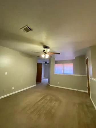 an empty room with a ceiling fan and hardwood floor