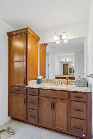 a bathroom with a granite countertop sink and a mirror
