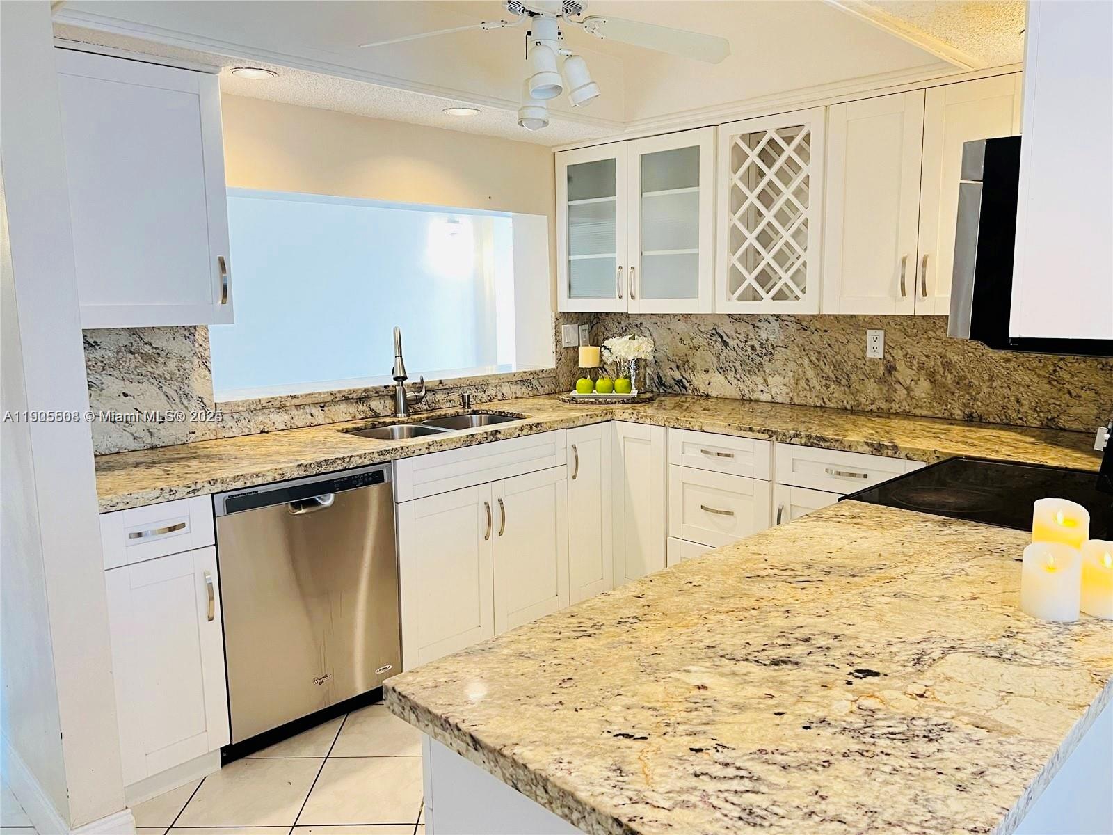 1830 Sabal Palm Drive, Unit 406 Davie, FL 33324 - Photo 2 of 16 a kitchen with stainless steel appliances granite countertop a sink stove and refrigerator