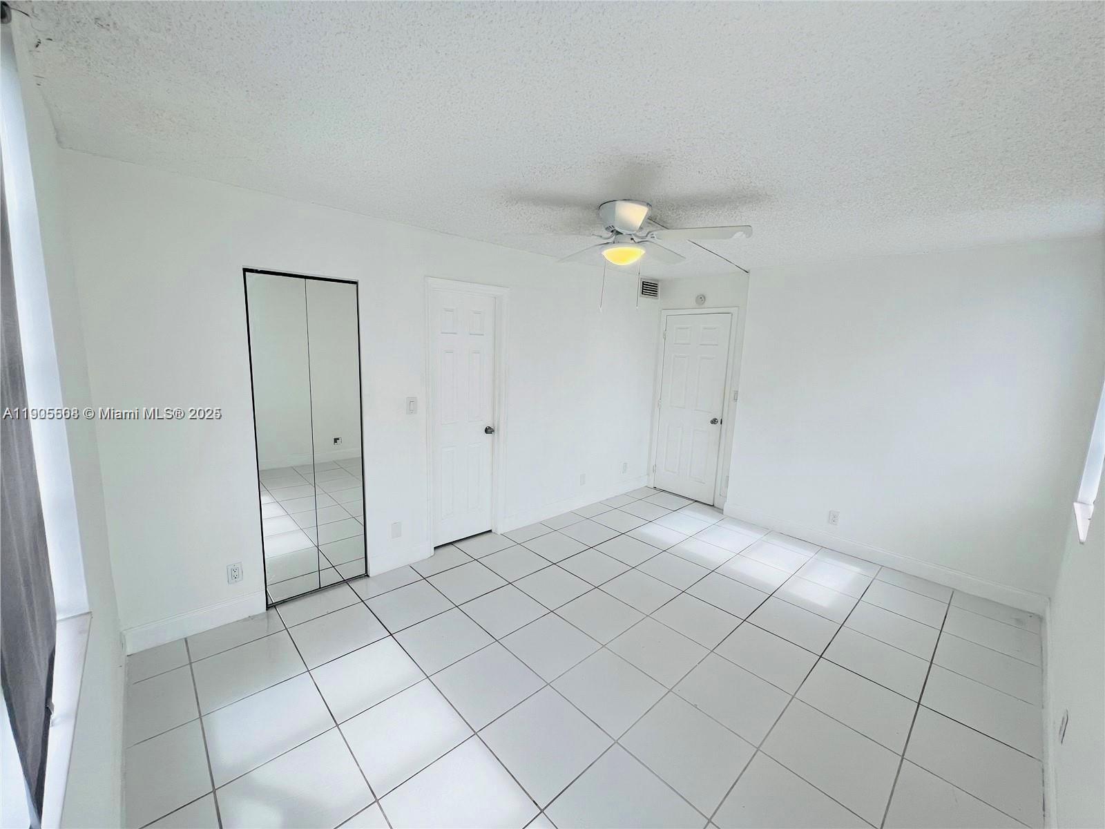 1830 Sabal Palm Drive, Unit 406 Davie, FL 33324 - Photo 4 of 16 an empty room with white wall and chandelier fan