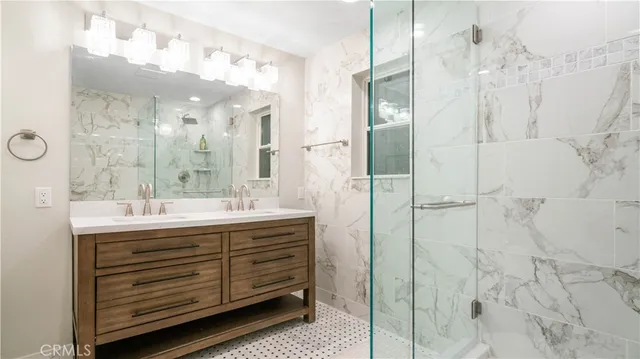 a bathroom with a double vanity sink mirror and shower