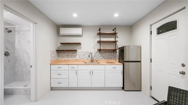 a kitchen with white cabinets and refrigerator