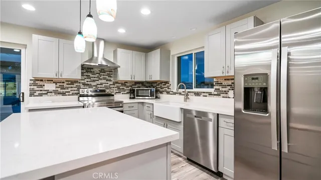 a kitchen with white cabinets and stainless steel appliances