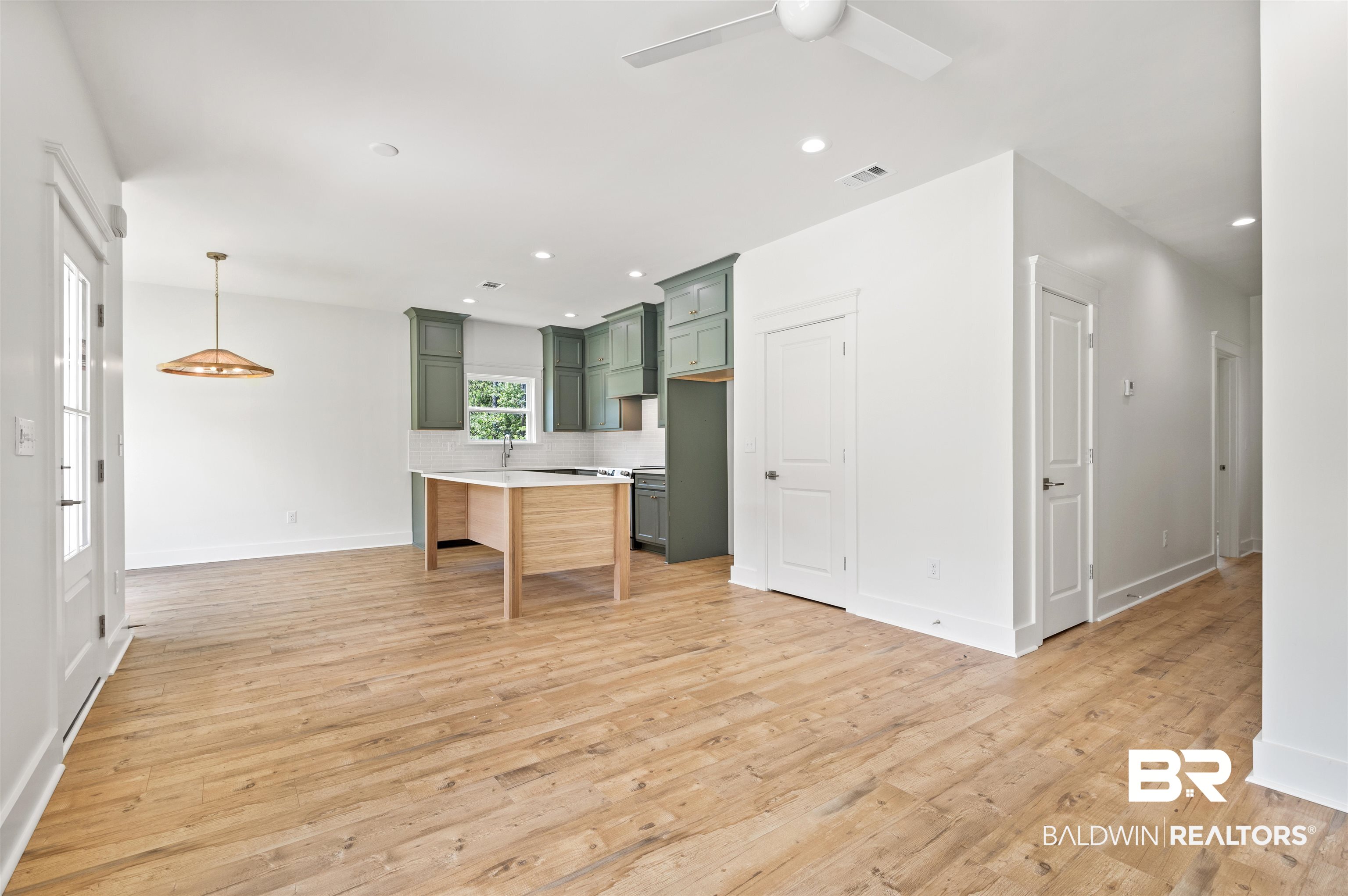 657 Island Way Gulf Shores, AL 36542 - Photo 10 of 59 Kitchen with green cabinets, light wood-style floors, light countertops, decorative backsplash, and recessed lighting