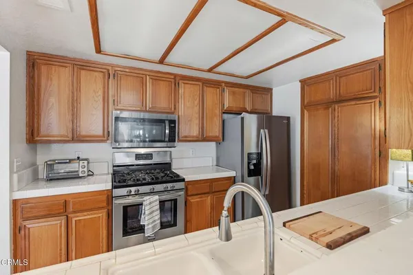 a kitchen with stainless steel appliances granite countertop a refrigerator stove top oven a sink and dishwasher