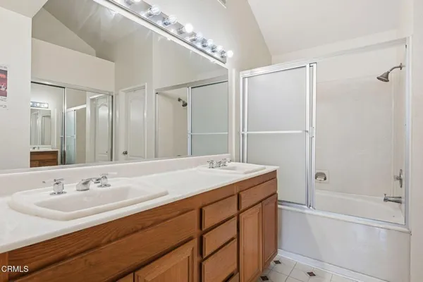 a bathroom with a sink double vanity granite tub and shower