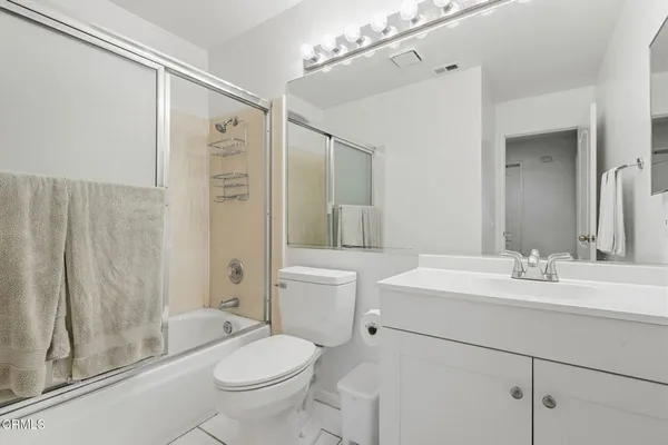 a bathroom with a sink vanity mirror and toilet