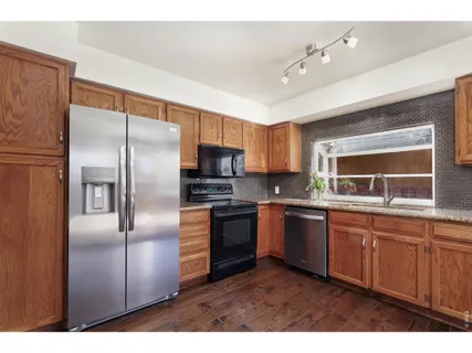a kitchen with kitchen island a counter top space appliances and a sink