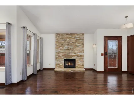 a view of empty room with wooden floor and fireplace