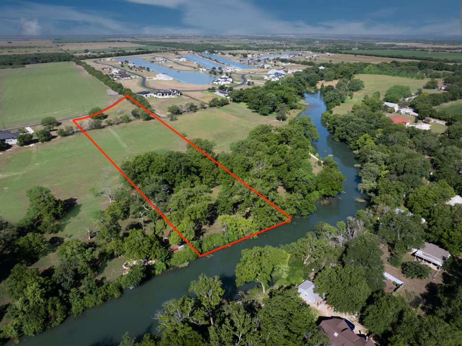 110 Rustic River Street Martindale, TX 78655 - Photo 2 of 28 Aerial view of sparsely populated area featuring a large body of water and property parcel outlined