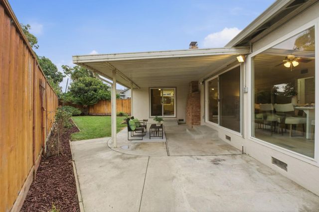 a view of a backyard with potted plants and wooden fence