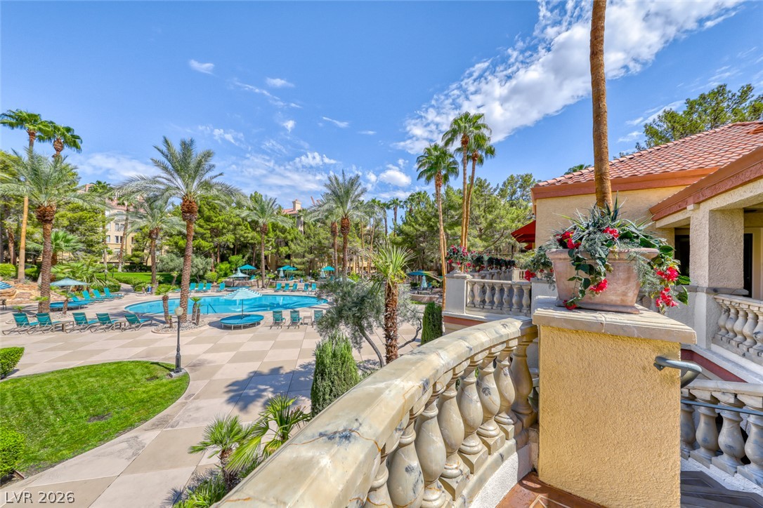 210 East Flamingo Road, Unit 112 Las Vegas, NV 89169 - Photo 37 of 59 A spacious stone terrace overlooks the resort-style community pool surrounded by towering palm trees.