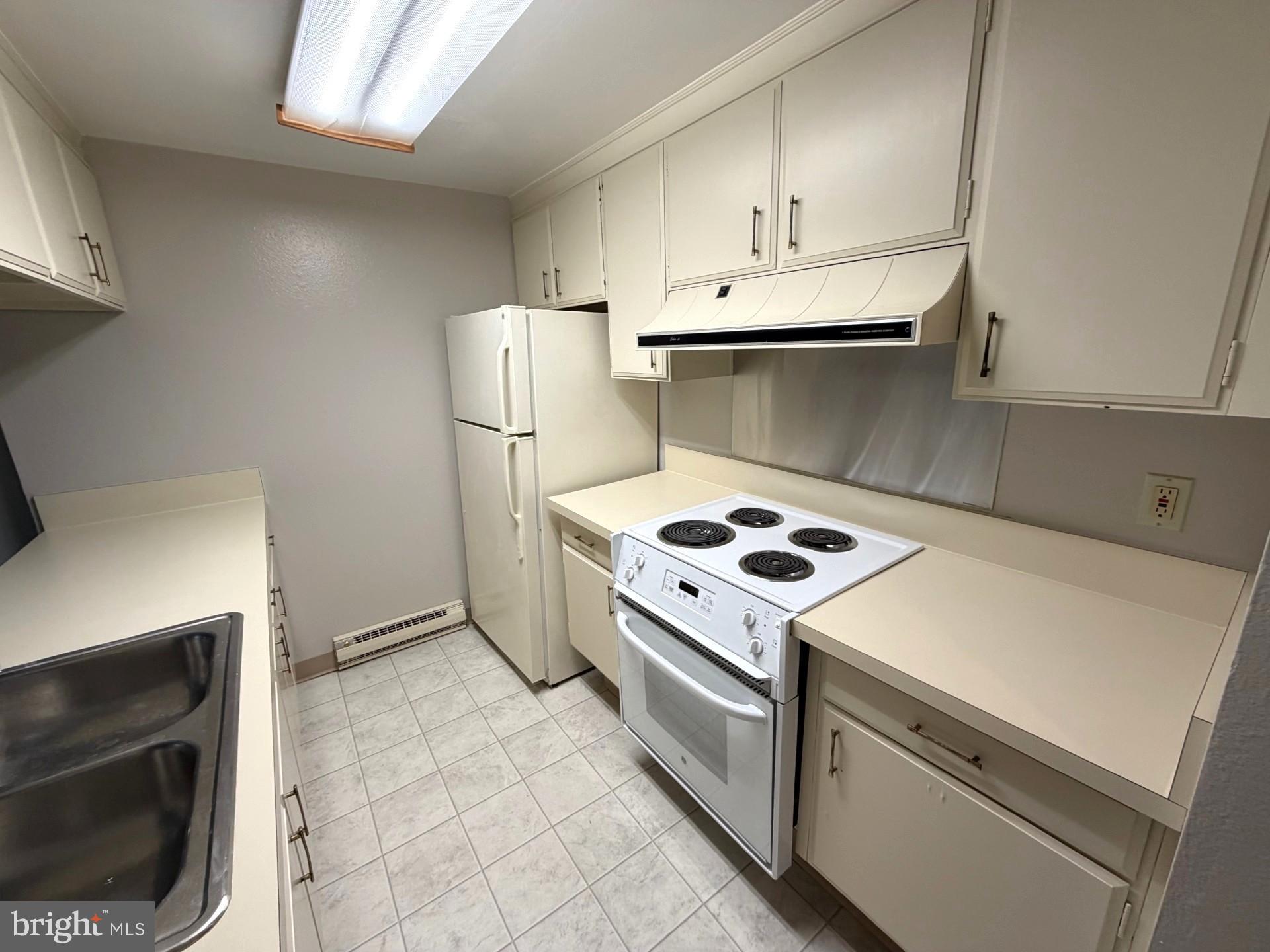 3320 Chiswick Court, Unit 611D Silver Spring, MD 20906 - Photo 15 of 38 a kitchen with a stove top oven and cabinets
