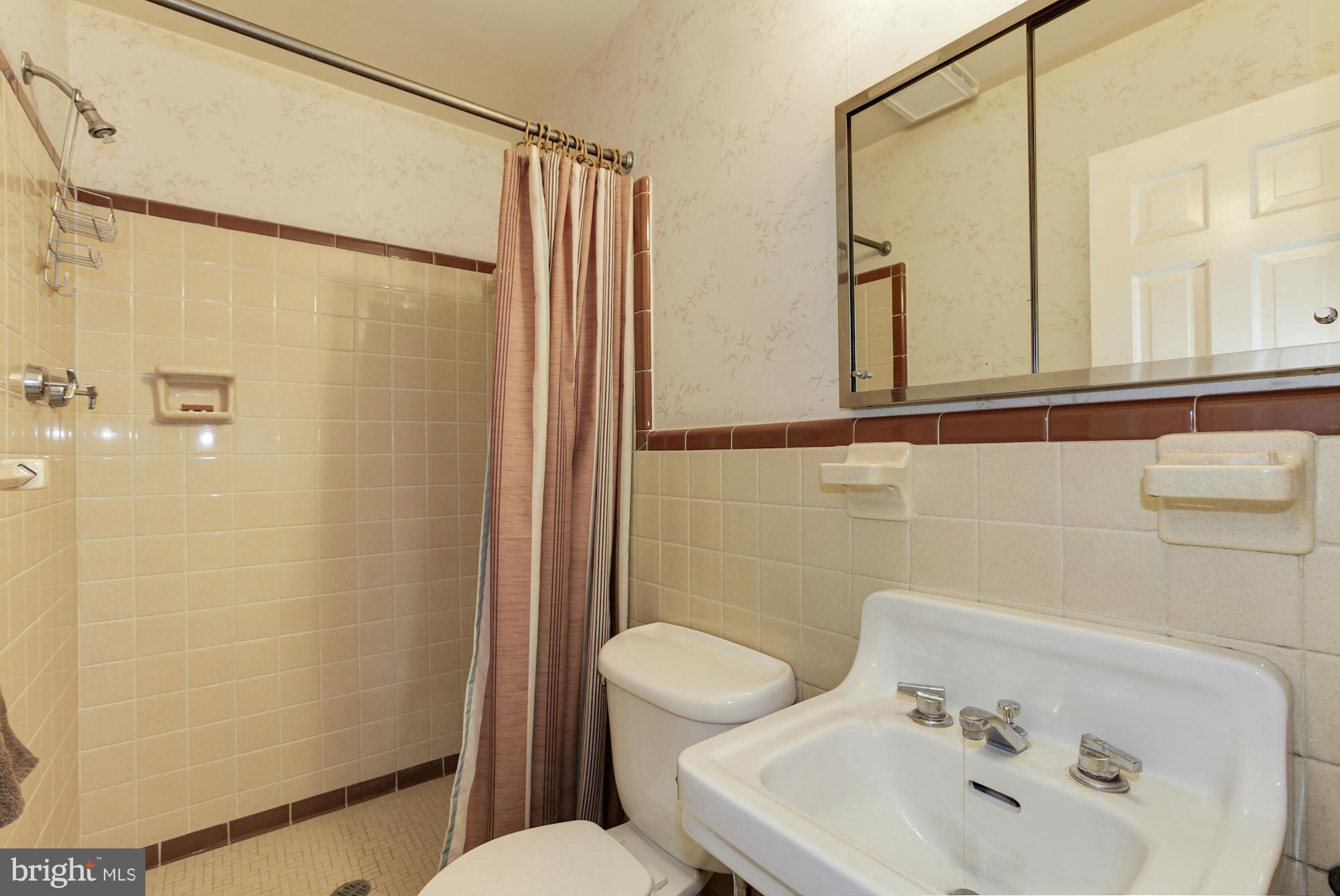 5502 Pollard Road Bethesda, MD 20816 - Photo 18 of 30 a bathroom with a sink a mirror and a shower