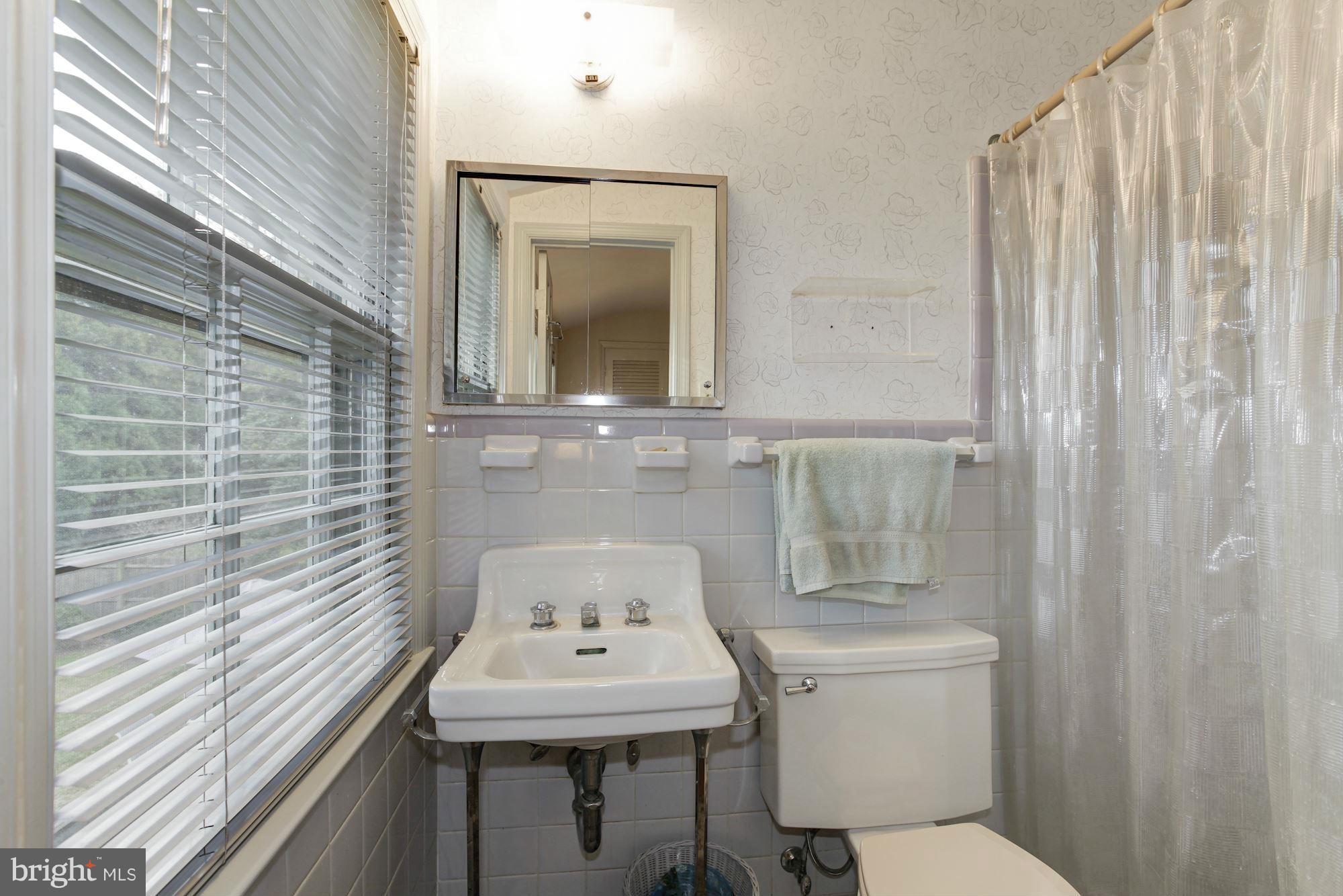 5502 Pollard Road Bethesda, MD 20816 - Photo 21 of 30 a bathroom with a toilet a sink and mirror