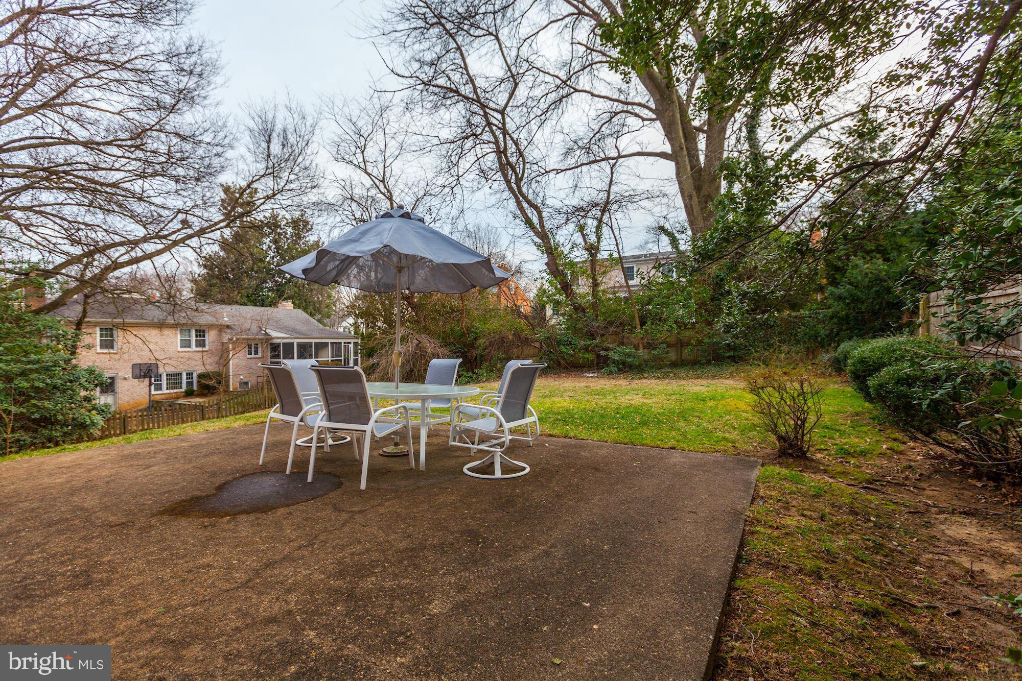 5502 Pollard Road Bethesda, MD 20816 - Photo 27 of 30 a view of a backyard with table and chairs under an umbrella