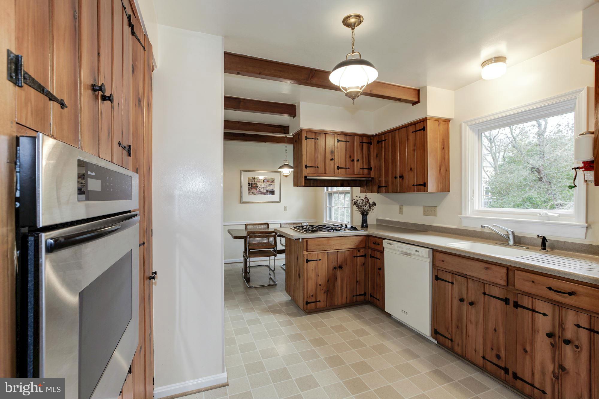 5502 Pollard Road Bethesda, MD 20816 - Photo 9 of 30 a kitchen with stainless steel appliances granite countertop a sink a stove a refrigerator cabinets and a window