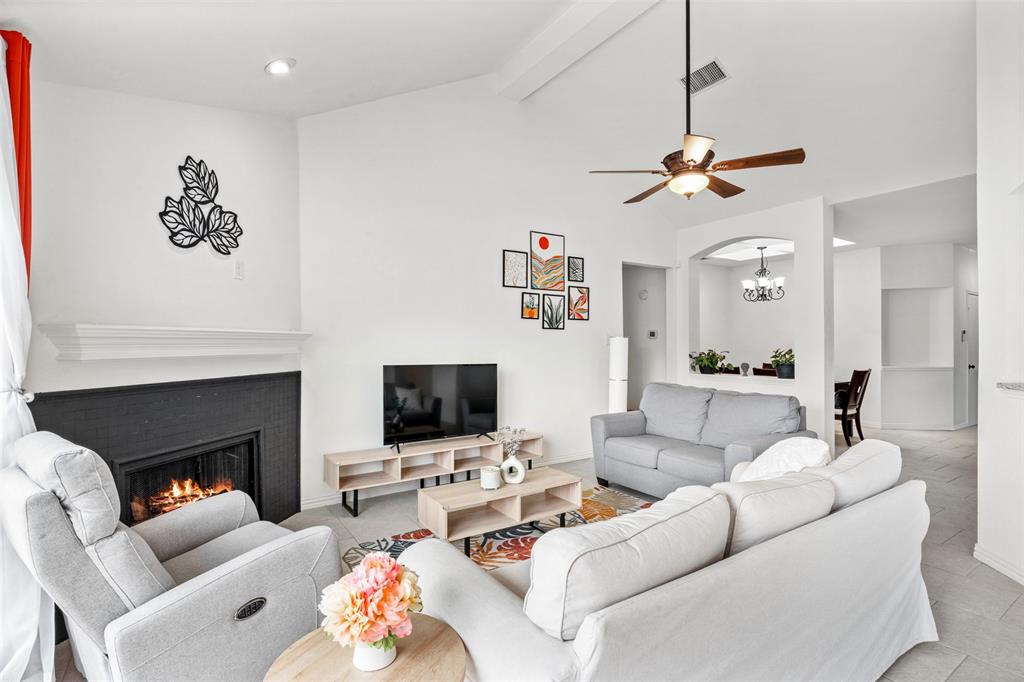 1011 Ridgecrest Drive McKinney, TX 75069 - Photo 10 of 31 Spacious living area featuring a central fireplace with a dark-finished surround and white mantel