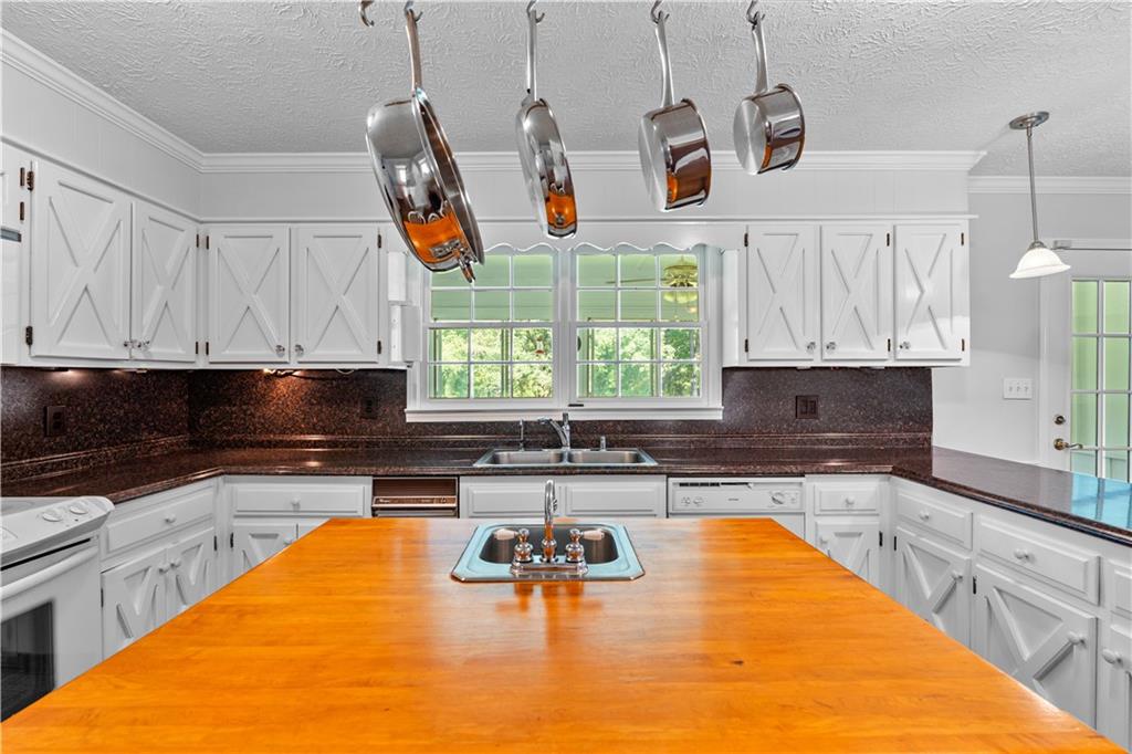 894 Upper Woolsey Road Hampton, GA 30228 - Photo 19 of 96 a kitchen with stainless steel appliances granite countertop a sink a stove and a microwave