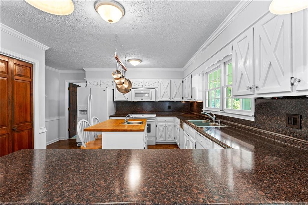 894 Upper Woolsey Road Hampton, GA 30228 - Photo 21 of 96 a kitchen with granite countertop a stove a sink and a refrigerator