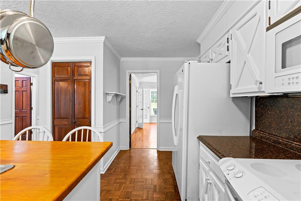 894 Upper Woolsey Road Hampton, GA 30228 - Photo 23 of 96 a kitchen with stainless steel appliances granite countertop a refrigerator a stove and a sink with wooden floor