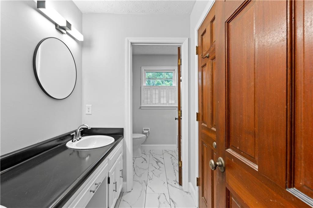 894 Upper Woolsey Road Hampton, GA 30228 - Photo 41 of 96 a bathroom with a granite countertop sink and a mirror