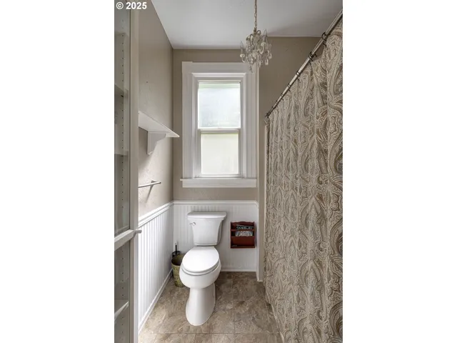 a bathroom with a toilet and a shower curtain